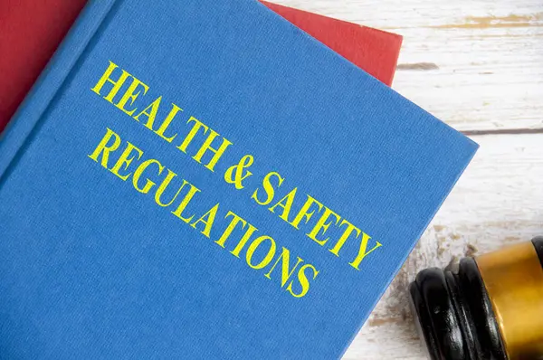 Top view of Health and Safety Regulations on blue book with gavel background. Law concept.