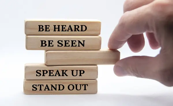 Be heard, be seen, speak up, stand out text on wooden block. Business concept.