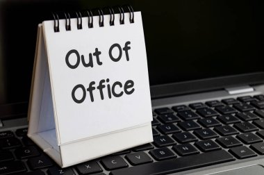 Not defterine dizüstü bilgisayarla yazılmış ofis dışı mesajlar. Ofis dışı konsept.
