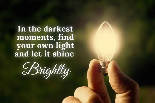 Motivational quote about darkest moments with closeup light bulb background.