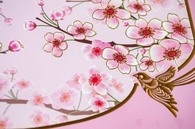 Çin Yeni Yıl dekorasyonu. Kuşlar ve pembe arka planda çiçekler..