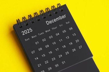 Aralık 2025, sarı kapaklı siyah beyaz masa takvimi. Takvim kavramı.