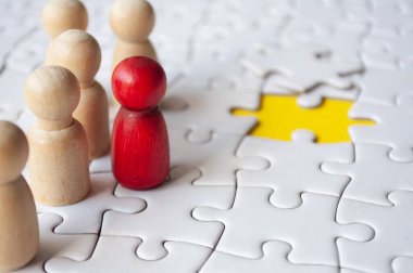 Tahta bebekler yapbozun üzerinde kayıp yapboz parçaları. İşe alma ve istihdam kavramı