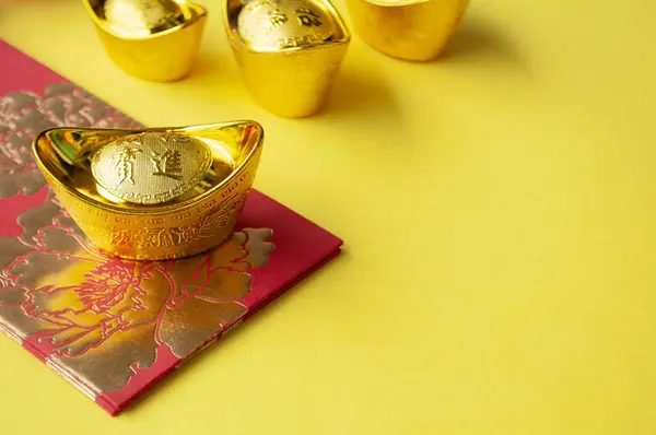 Golden ingot on top of red packets with customizable space for text or wishes.