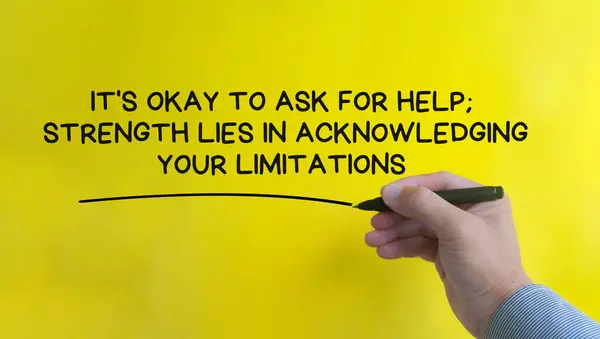 Hand writing It is okay to for help affirmation on yellow cover background. Affirmation concept