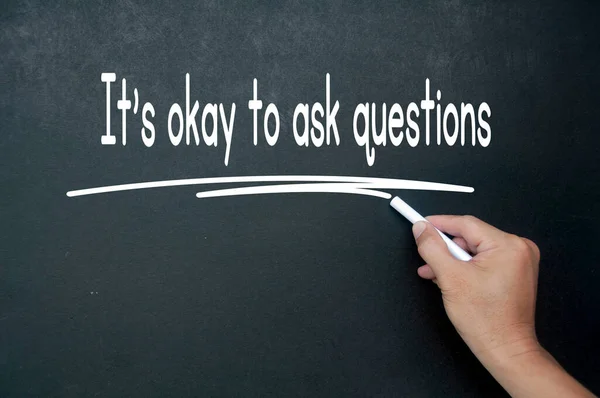 Hand writing It is okay to ask questions affirmation on black board. Affirmation concept.