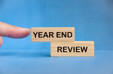 Ahşap blokta mavi arka planda Yıl Sonu İncelemesi metni var. Orta vadeli bütçe kavramı.