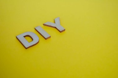 Sarı arka planda kendini temsil eden ahşap harfler..