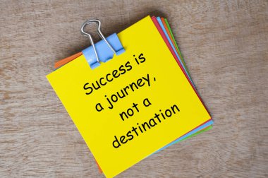 Success is a journey, not a destination text on yellow notepad. clipart