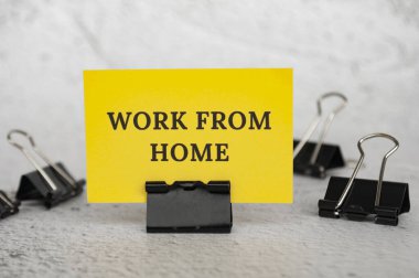 Work from home text on standing yellow paper. Working culture concept. clipart