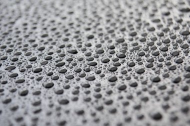 Koyu arkaplanda yağmur damlalarının yan görünümü.