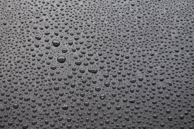 Koyu arkaplanda yağmur damlalarının en üst görünümü.