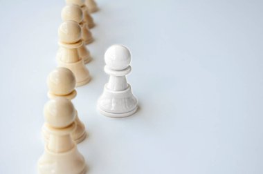 White shining pawn stepping out from the rest of the soldier pawn. Leadership concept clipart