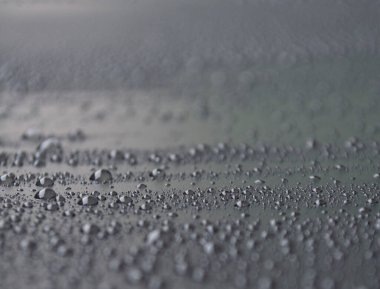 Siyah duvar kağıdı arkaplanı olan su damlacıklarının yan görünümü