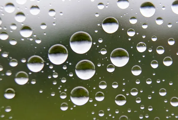 stock image Straight view of water droplets on clear glass on blurred nature background. Suitable for design and wallpaper