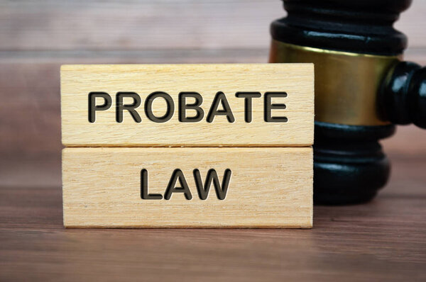 Probate law text engraved on wooden blocks with gavel background. Law concept.
