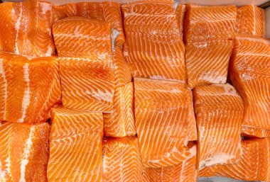 Islak pazarda sergilenen taze çiğ somon filetosunun üst görüntüsü.