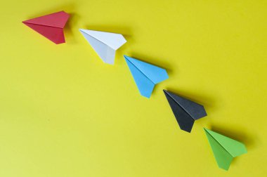 Kırmızı kağıttan uçak, çok renkli kağıt uçakların geri kalanına yazı için özelleştirilebilir alan sağlıyor..