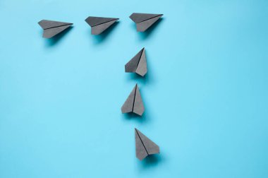 Tek bir yöne doğru uçan siyah kağıt uçakların üst görüntüsü. İş ve hedef kavramı.