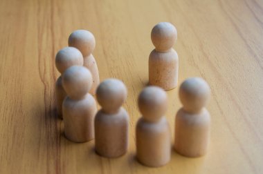 Tahta figür diğer figürlere önderlik ediyor. Liderlik kavramı.