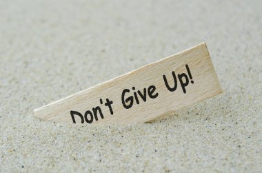 Tahta çubukla yazılmış ve kumsal arkası kum olan metinden vazgeçme. Motivasyon kavramı.