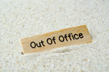 Ofis dışı mesajı, tahta çubukta, kumlu arka planda. İş dışı konsept. 