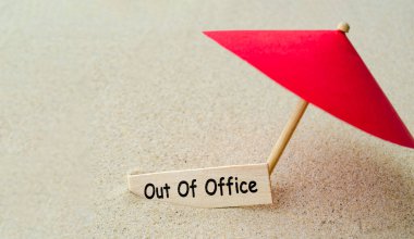 Ofis dışı metinde tahta pankartta görev dışında temsil edilen oyuncak şemsiyeyle..