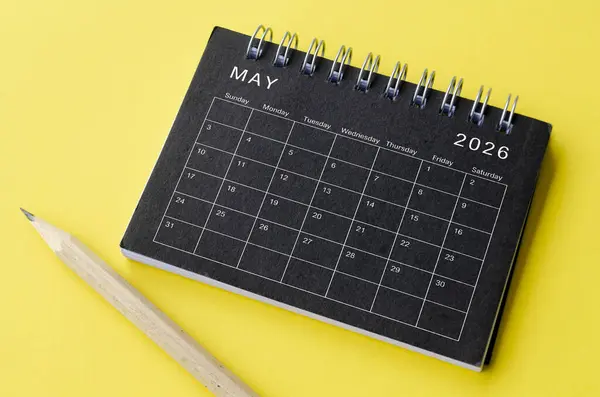 stock image Top view of May 2026 calendar on black notepad with yellow background. Calendar concept.