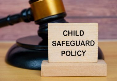 Child Safeguard Policy text on wooden blocks with gavel background. Safeguarding child policy concept. clipart