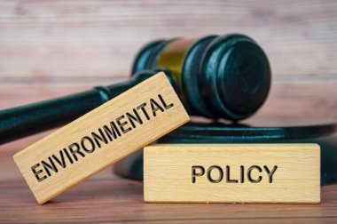 Tahta bloklara oyulmuş tokmak arkaplanlı çevre politikası metni. Çevre politikası kavramı