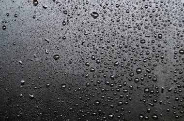 Karanlık arka planda su damlacıklarının düz görüntüsü. Su ya da yağmur damlacıkları ve duvar kağıdı tasarımı kavramı.