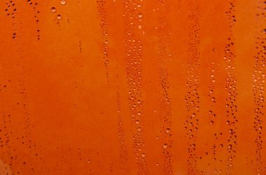 Duvar kağıdı dekorasyonu veya tasarımı için uygun turuncu arkaplan üzerine yağmur damlacıkları.