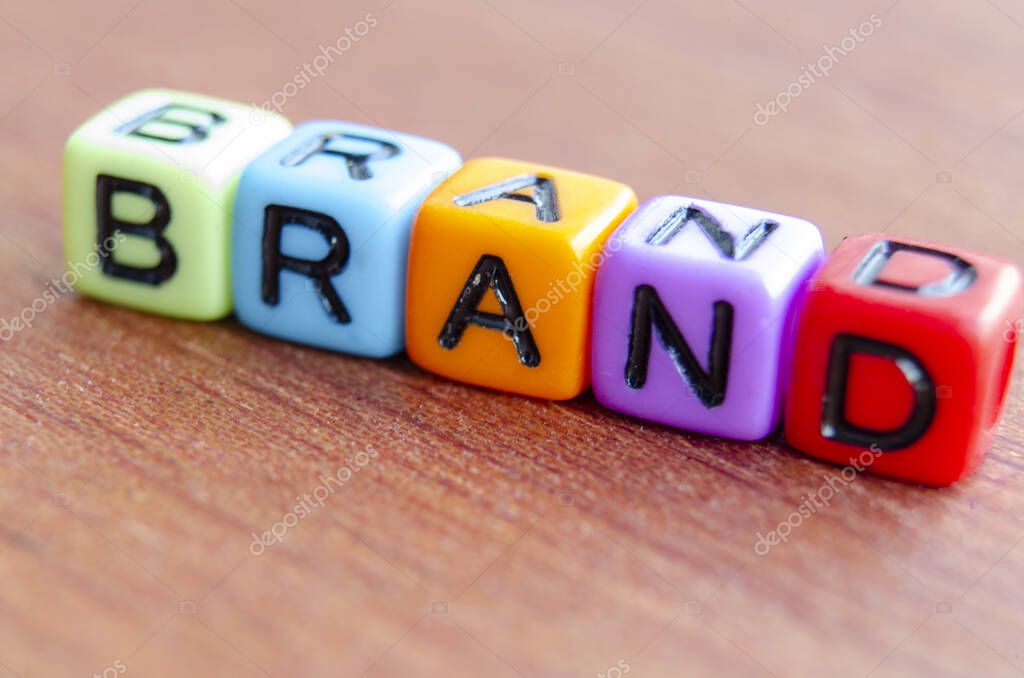 Brand text multicolor cubes on wooden table.