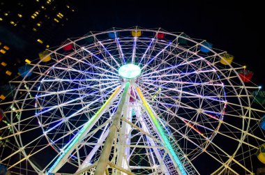 Bright ferris wheel. Vacation and night outing with family and children. Holiday concept. clipart