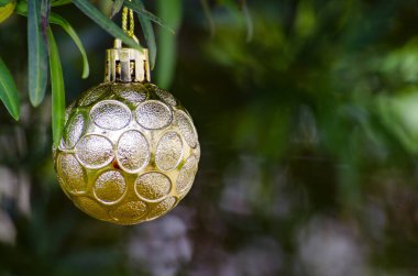 Noel dilekleri için kişiselleştirilebilir alanı olan, bulanık Noel ağaçları olan altın bir Noel balosu. Mevsimler selamlar.