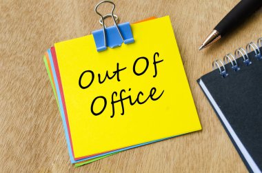Ofis dışı metnin üst görüntüsü sarı not defterinde. Tatil ya da tatil ve iş kavramından uzaklaşmak.