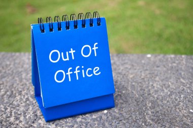 Ofis dışı metninin yan görüntüsü mavi not defterinde. İş dışı konsept.