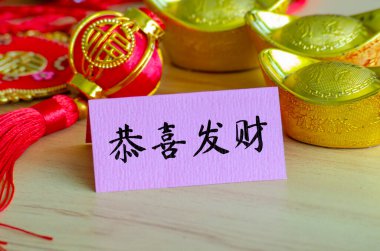 Çin Yeni Yıl Tebrik ve Dilekleri karakteri Çin Yeni Yıl dekorasyonuyla Gong Xi Fa Cai 'yi not defterinde söylüyor..