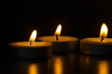 Karanlıkta parlayan mumlar mesaj, metin ya da fikirler için özelleştirilebilir alanla dini dua anını temsil ediyor. Dini ve dua kavramı.