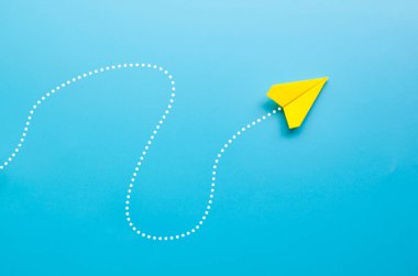 Origami sarı kağıt uçak üst görünümü mavi arkaplan üzerinde kişiselleştirilebilir boşluk metin için.