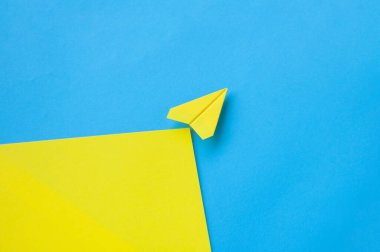 Metin için özelleştirilebilir alanı olan sarı kağıt uçağın üst görünümü.