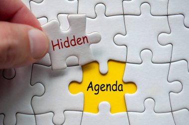 Hidden Agenda text on jigsaw puzzle. Unknown motif concept. clipart