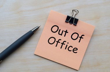 Ofis dışı metnin tahta masadaki üst görünümü.