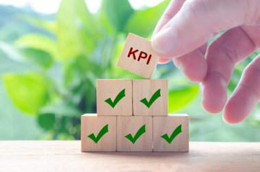 KPI yazılı ahşap küple el ele tutuşmak. Anahtar Performans Göstergesi konsepti