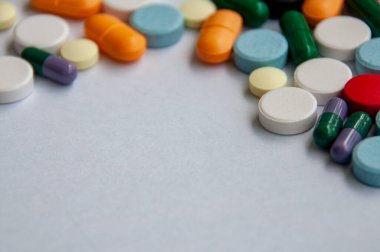 Renkli haplar ve kapsüller beyaz kapak arka planına dağılmış ve metin için özelleştirilebilir boşluk.