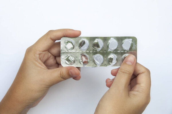 Hand showing empty pill or capsule with customizable space for text. Medical and health matters concept