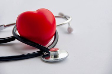 Beyaz zemin üzerinde kırmızı kalpler şekilli steteskop görüntüsünü kapat ve metin için özelleştirilebilir alan oluştur. Tıbbi ve sağlık konsepti