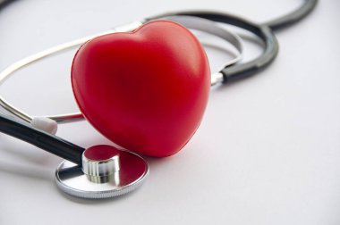 Beyaz zemin üzerinde kırmızı kalpler şekilli steteskop görüntüsünü kapat ve metin için özelleştirilebilir alan oluştur. Tıbbi ve sağlık konsepti.