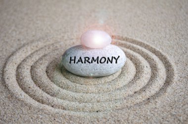 Zen ağacına kazınmış harmoni metni ve kumların tepesinde parlayan taş..