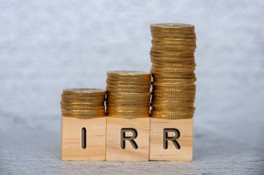 Tahta küplerle altın sikkeleri üst üste istifleyen cevap metinlerinin iç oranları. IRR ve yatırım kavramı.